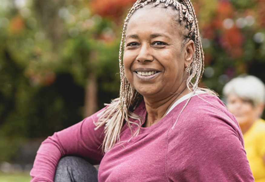 Smiling woman wearing exercise clothes and stretching.