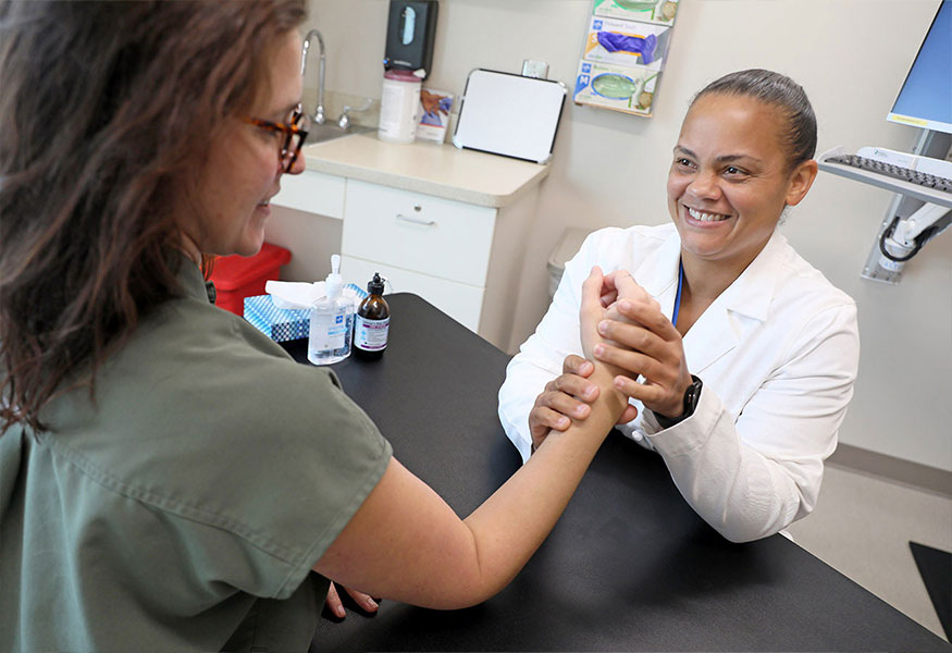 An orthopedist  examining a patient's wrist.